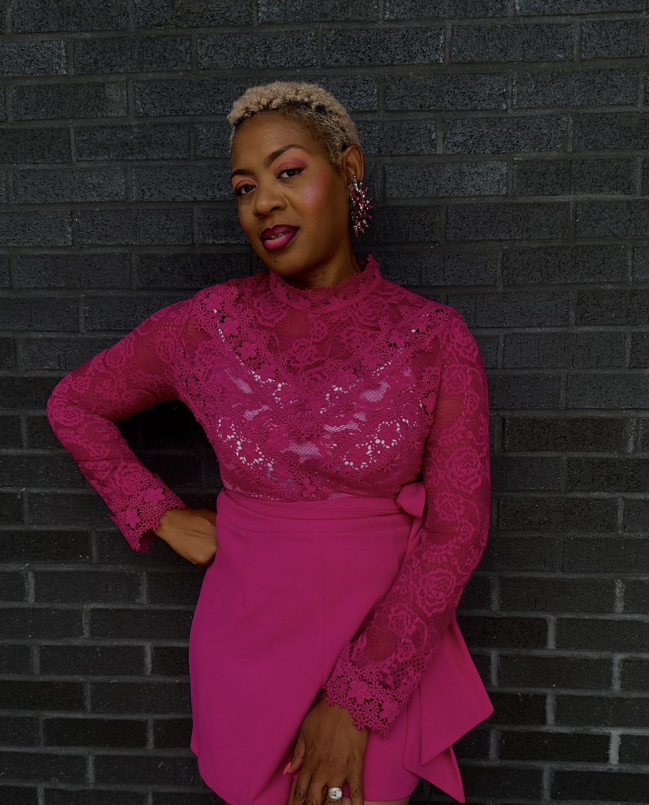 Jennettia, founder of The Cloth Story, wearing a vibrant pink lace outfit